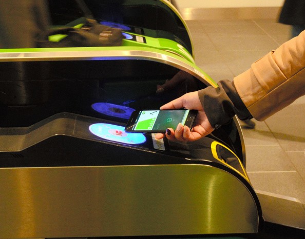 Commuter places iPhone 7 on the card reader to walk through a ticket gate