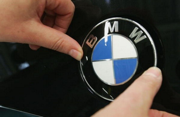 A worker fixes a BMW hood ornament onto a new BMW 3-series car on the day of the plant's offical opening on May 13, 2005 at the BMW factory in Leipzig, Germany.