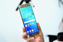 User holds Samsung Galaxy S6 edge+.