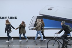 Pedestrians pass through the Samsung Galaxy S8 billboard.