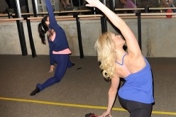 Two women are performing exercise routines in the gym to keep fit.