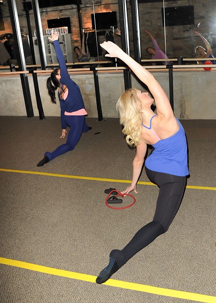 Two women are performing exercise routines in the gym to keep fit.
