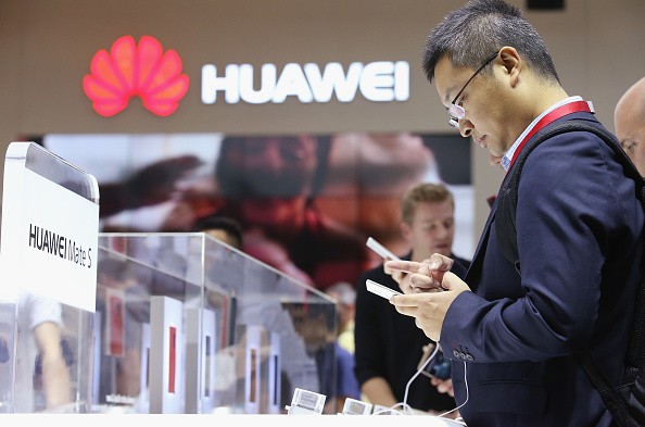 Visitors try out the Huawei Mate S smartphone at the Huawei stand at the 2015 IFA consumer electronics and appliances trade fair on September 4, 2015 in Berlin, Germany.