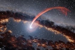 This illustration released on Sept. 15, 2016 shows a glowing stream of material from a star, disrupted as it was being devoured by a supermassive black hole.