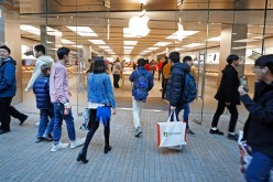 Shoppers enter an Apple store on black Friday to search for the best deals.