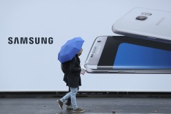People walk past an advertisement for one of 2016's biggest tech releases: The Samsung S7 Edge.