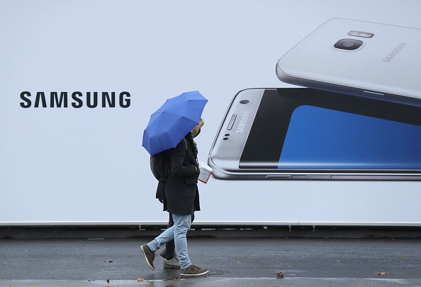 People walk past an advertisement for one of 2016's biggest tech releases: The Samsung S7 Edge.