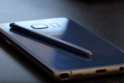 A Samsung phone rests on a platform while its stylus is being featured on top of the said Android smartphone.