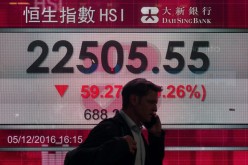 A man walks past a display board showing the Hang Seng Index during the first day of the Shenzhen-Hong Kong Stock Connect early this month.