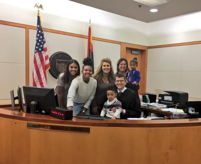 Michael Brown poses for a photo with his new family and the judge that finalised his adoption last Dec. 20.
