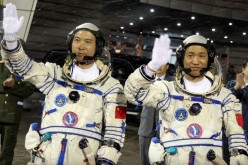 Chinese astronauts Fei Junlong (L) and Nie Haisheng wave before boarding the Shenzhou VI spacecraft at Jiuquan Satellite Launch Center on October 12, 2005 in Jiuquan of Gansu Province, northwest China