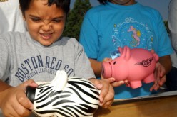 Michael Khatchadourina, 7, tries to open his piggy bank as he and his sister Krysta, 9, make a donation for victims of Hurricane Katrina at a daylong disaster relief collection event.