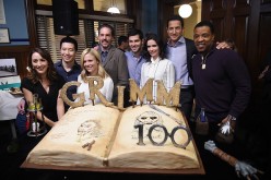 'Grimm' cast members pose in front of a cake celebrating the 100th episode of the series on November 10, 2015 in Portland, Oregon. 
