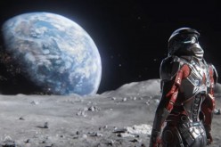 A character from 'Mass Effect: Andromeda' is standing on the surface of the moon, while facing the earth. 