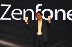  Asus CEO, Jerry Shen, is holding two Asus smartphones in his hands during a company event. 