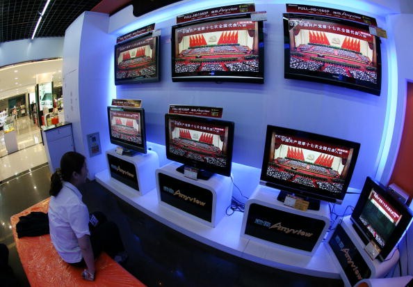 A woman views TV screens showing Chinese President Hu Jintao delivering a speech during the opening ceremony of the 17th CPC National Congress, at a department store on Oct. 15, 2007, in Nanjing.
