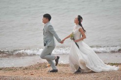 A couple takes wedding photos by the sea in Qingdao.
