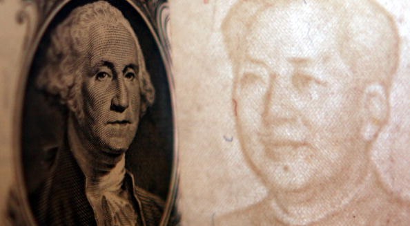 Details of dollar and a yuan notes are seen at a bank on May 15, 2006 in Beijing, China.