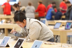 A customer at an Apple store testing out different products before making his Black Friday purchase.