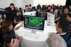 Attendees inspect the new 27 inch iMac with 5K Retina display during an Apple special event on October 16, 2014 in Cupertino, California.