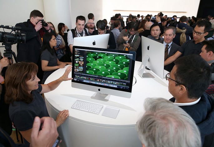 Attendees inspect the new 27 inch iMac with 5K Retina display during an Apple special event on October 16, 2014 in Cupertino, California.