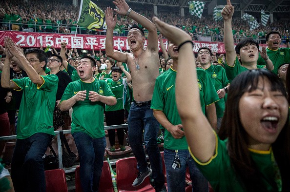 Fans of the Chinese Super League club Beijing Ultras celebrate after their side scored a goal against Chongcing Lifan FC last June 28, 2015.