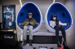 A Chinese couple wear virtual reality (VR) glasses in a VR arcade.