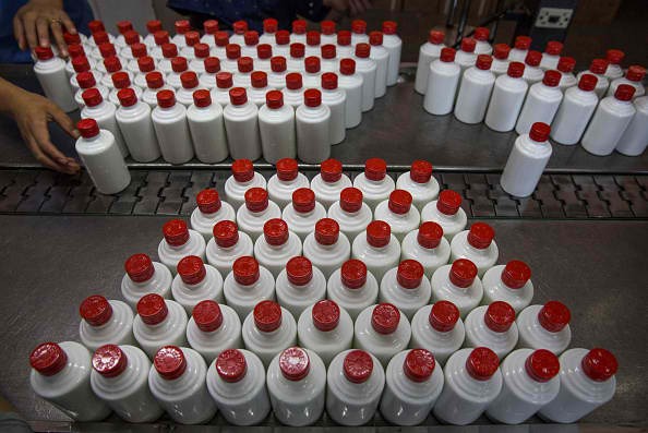 A Chinese worker arranges bottles of quality locally made wine called baijiu at the Guizhou Huaizhuang Liquor Group.