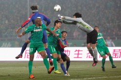 Shanghai Shenhua goalkeeper Wang Dalei punches away a shot from Da Costa Reinaldo Elias of Beijing Guoan in their matchup last Mar. 16, 2012.