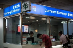 A man changes foreign currency into Chinese yuan at a currency exchange office at Hongqiao airport in Shanghai.