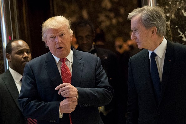 L to R) President-elect Donald Trump and French businessman Bernard Arnault, chief executive officer of LVMH, emerge from the elevators to speak to reporters at Trump Tower, Jan. 9, 2017, in NY.