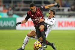 AC Milan striker Carlos Bacca (L) competes for the ball against Cagliari's Bruno Alves.