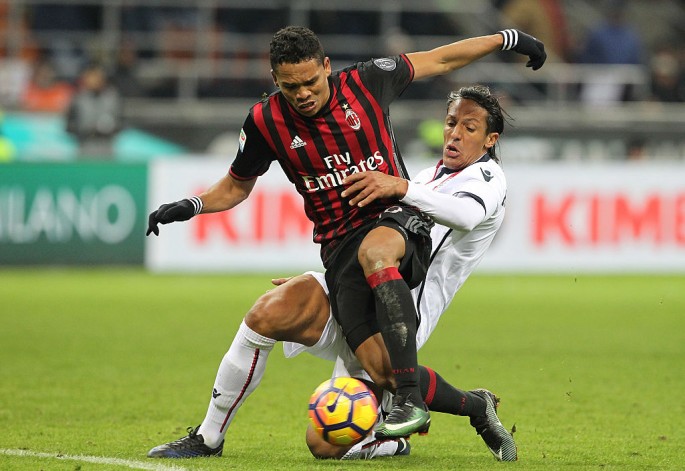 AC Milan striker Carlos Bacca (L) competes for the ball against Cagliari's Bruno Alves.