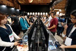 Visitors play a video game on Sony Interactive Entertainment Inc. PlayStation 4 game consoles the Bandai Namco Holdings Inc. booth at the Tokyo Game Show 2016 on September 15, 2016 in Chiba, Japan.