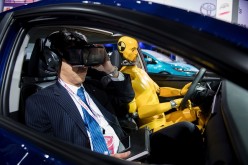 A reporter uses an Oculus Rift virtual reality headset during a Toyota safety demonstration at the 2017 North American International Auto Show. 