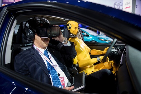 A reporter uses an Oculus Rift virtual reality headset during a Toyota safety demonstration at the 2017 North American International Auto Show. 