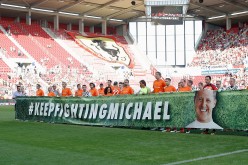  Both teams hold up a banner that reads 'Keep fighting Michael' prior to the 'Champions for charity' football match between Nowitzki All Stars and Nazionale Piloti in honor of Michael Schumacher at Opel Arena on July 27, 2016 in Mainz, Germany.