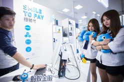Twin girls pay by facial recognition on the computer at the Ant Financial booth during the 2016 Computing Conference at Yunqi Cloud Town in Hangzhou.