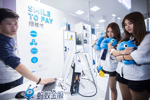 Twin girls pay by facial recognition on the computer at the Ant Financial booth during the 2016 Computing Conference at Yunqi Cloud Town in Hangzhou.
