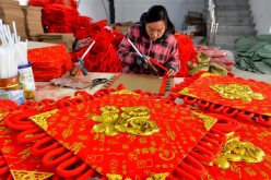 A woman makes a Chinese knot for a wall decoration at Liujing village, Xiayi township in Central China's Henan Province, Dec 3, 2016. 