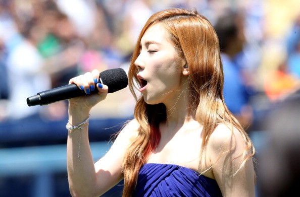 Taeyeon of Korean Pop group Girls Generation sings the Korean national anthen during Korea Day ceremonies before the game between the Cincinnati Reds and the Los Angeles Dodgers at Dodger Stadium on July 28, 2013 in Los Angeles, California.