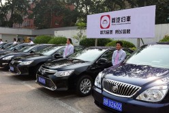 Drivers stand by cars of Shouqi Limousine & Chauffeur, a taxi-booking service, on Sept. 16, 2015, in Beijing, China.