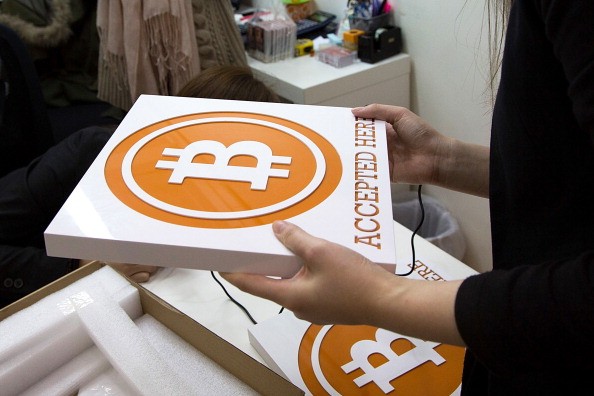 A worker holds a sign at the first bitcoin retail store to open in Hong Kong on Feb. 28, 2014.