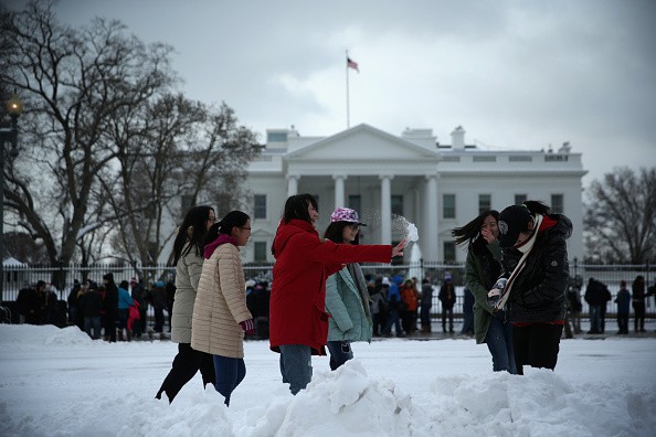 Chinese tourists from Beijing participate in a snowball fight in front of the White House, Feb. 17, 2015, in Washington, DC.