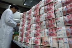 An employee counts 100 yuan banknotes at the Korea Exchange Bank headquarters in Seoul. 