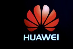 A Huawei logo is shown on a screen during a keynote address by CEO of Huawei Consumer Business Group Richard Yu at CES 2017.
