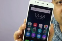 Vivo smartphone is held by hand to display its app features.