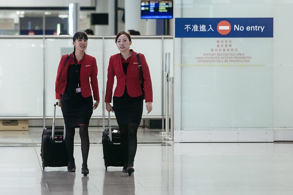 Cathay Pacific Airways Ltd. employees walk inside the terminal at Hong Kong International Airport in Hong Kong, China.