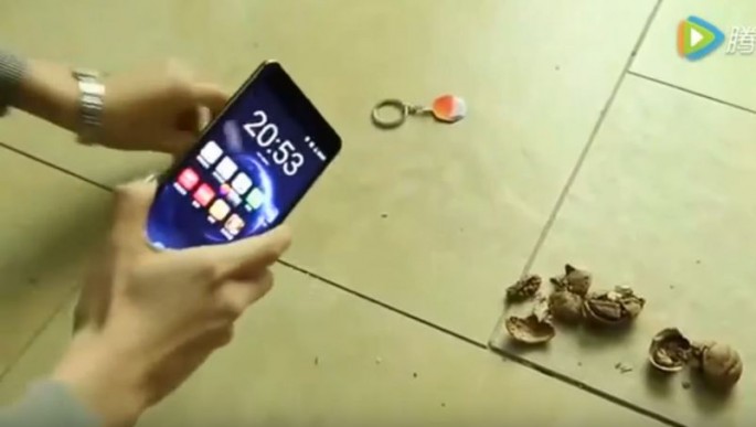 Nokia 6 smartphone is used by a user to crack walnuts. 