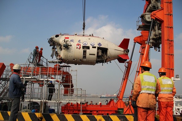 Workers install Jiaolong, China's manned deep-sea research submersible, onto its carrier.